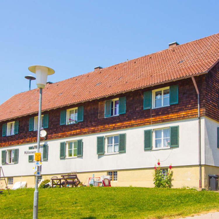 Ein Mehrfamilienhaus mit rotem Dach