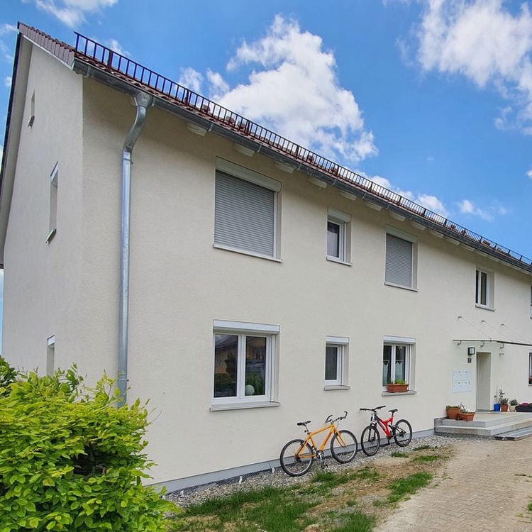 Wohnhaus mit Hecke und blauem Himmel