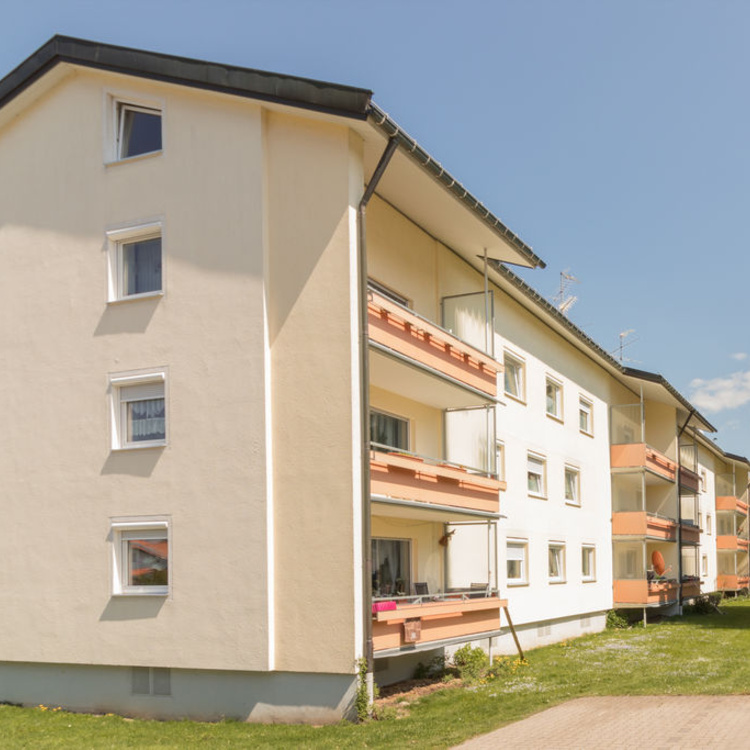 Ein Mehrfamilienhaus neben einer Wiese