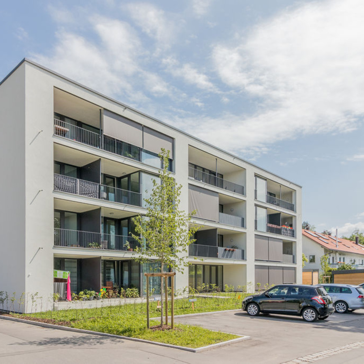 Ein Mehrfamilienhaus mit geparkten Autos