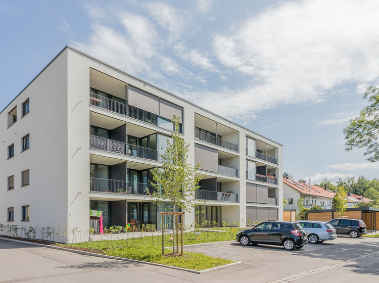 Ein Mehrfamilienhaus mit geparkten Autos