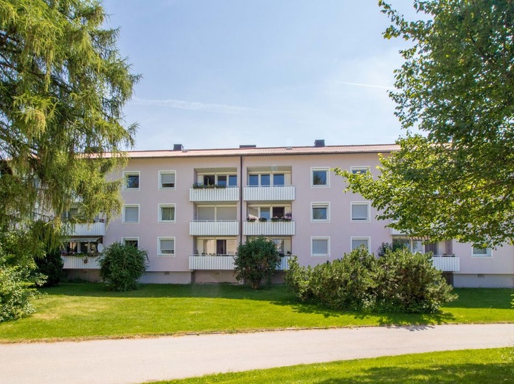 Ein Wohnhaus an einer Wiese mit Bäumen