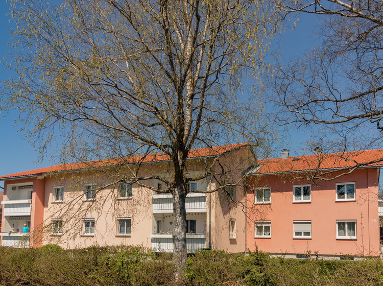 Ein Mehrfamilienhaus neben Bäumen
