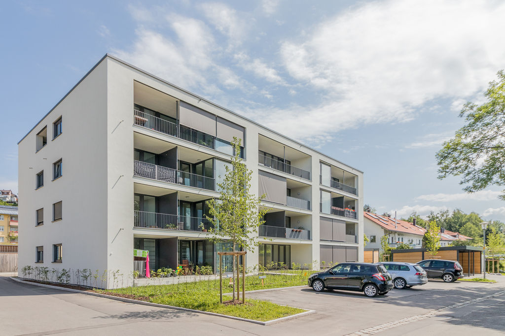 Ein Mehrfamilienhaus mit geparkten Autos