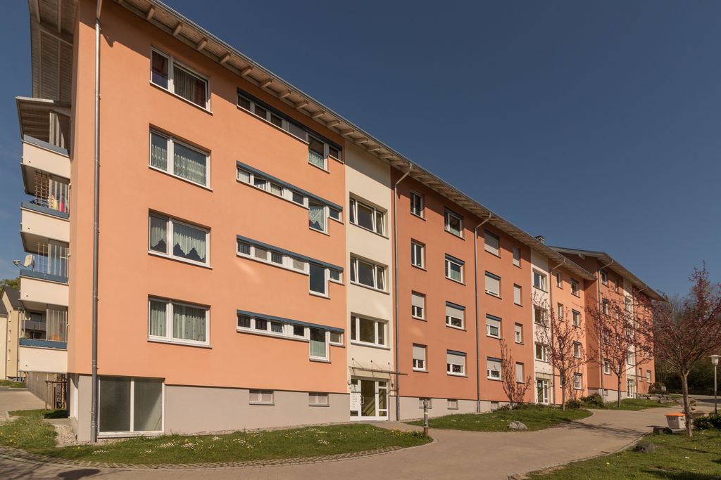 Ein Mehrfamilienhaus mit hellroter Fassade