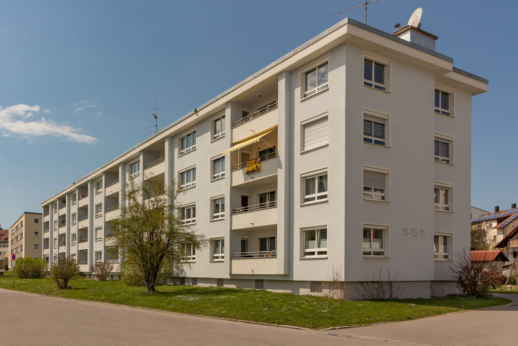 Ein Mehrfamilienhaus neben einer Rasenfläche